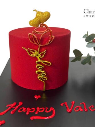 a red and gold cake with a rose and a flower